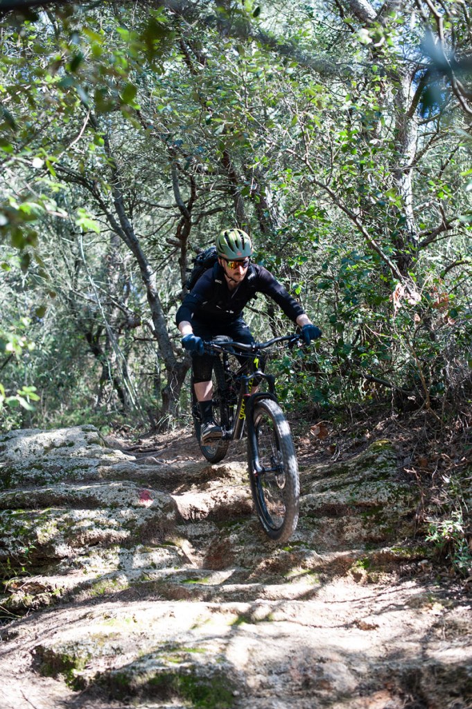 Mountainbiker auf felsigem Trail durch den mediterranen Wald