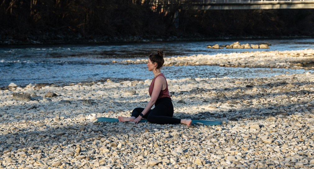 Frau macht Yoga for skiers an Fluss